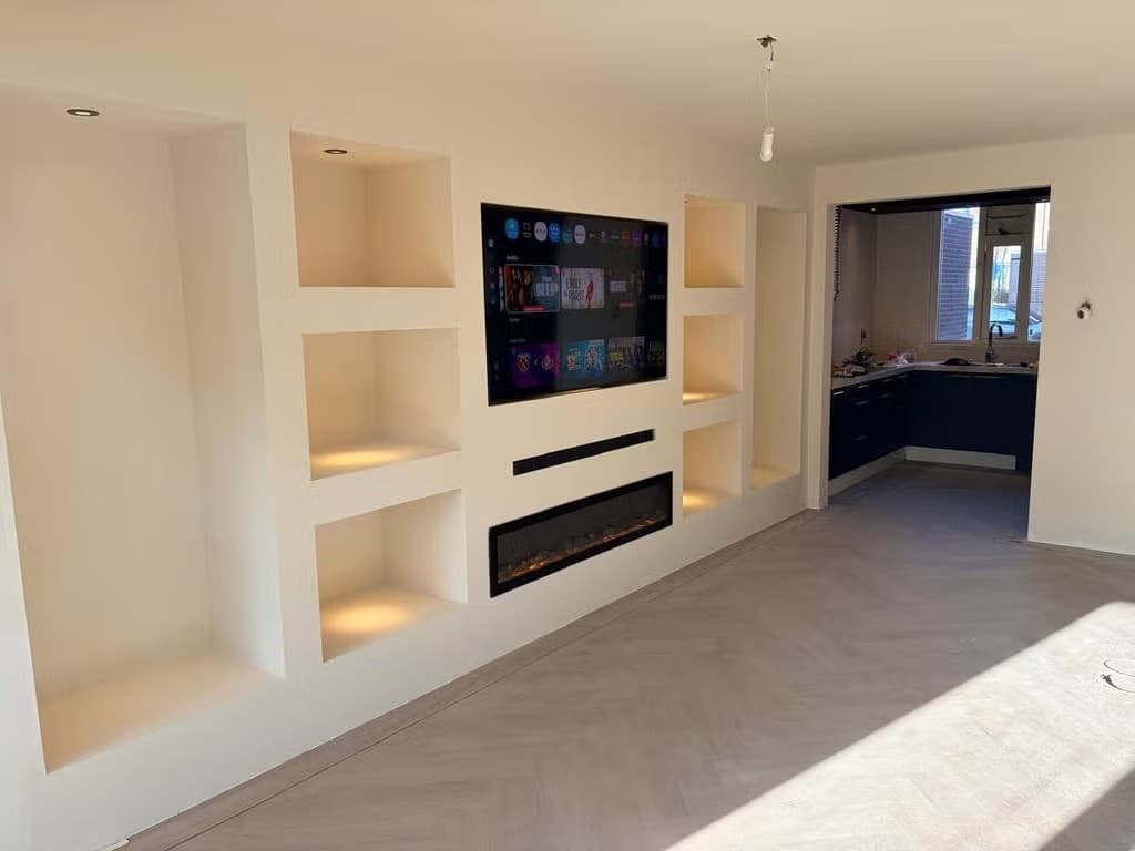 Gestucte tv-wand met symmetrische nissen en ingebouwde sfeerhaard